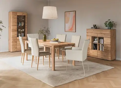 Esszimmer mit Holztisch, Polsterstühlen und Vitrine im Hintergrund